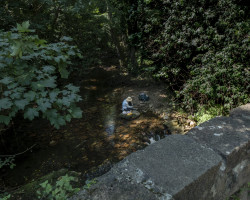 A pilgrim having lunch near a river. A pilgrim having lunch near a river